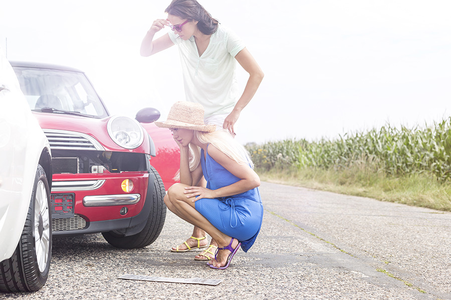 Tensed women looking at damaged cars